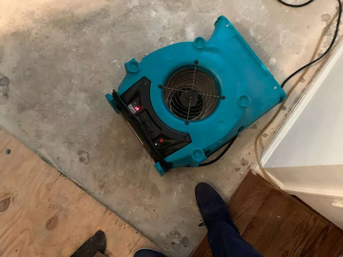 Air mover drying subfloor during Leak Detection & Repair in Cedarburg